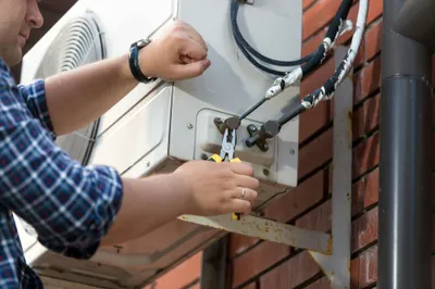 Technician repairing outdoor air conditioning unit